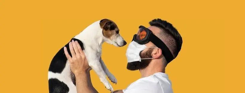 Man wearing a mask and holding a dog