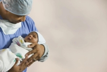 Black father holding a newborn child